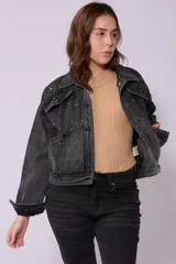 Campera de jean de lavado celeste claro, con diseño clásico de cuello y botones metálicos. Presenta detalles de pequeños brillos o tachas plateadas sobre la tela, especialmente visibles en los bordes de los bolsillos y costuras.