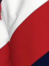 Short de baño con diseño de bloques de color diagonales en azul marino, blanco y rojo. Cintura elástica con cordón de ajuste rojo, bolsillos laterales y bolsillo trasero con cierre de velcro.