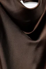 Top blanco satinado con cuello halter y escote fluido. Cierre en la espalda con botones.