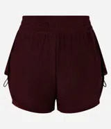 Bermuda deportiva femenina modelo runner, color bordó, con short interno incorporado. Presenta cintura elástica con cordón de ajuste y laterales con cordones ajustables. Confeccionada en tejido de tul con tecnología dry para mayor transpirabilidad.