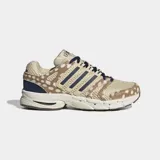 Championes Adidas Adistar Control 5 con diseño retro inspirado en los años 2000. Presenta parte superior de malla transpirable color beige con estampado animal print de leopardo, capas superpuestas de cuero peludo, las tres tiras características de la marca en azul marino y cordones oscuros.
