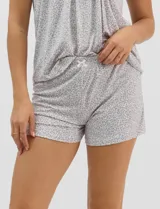 Pijama de dos piezas confeccionado en tejido soft con estampado animal print gris y blanco. Incluye una remera de manga corta con escote en V, detalle plisado en el frente y aplique de puntilla, y un short con cintura elastizada.