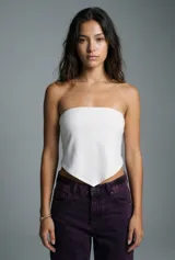 Top tipo bandeau blanco, ajustado al busto, con un corte inferior en forma de pico o pañuelo.