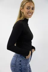 Polera color beige de manga larga y cuello alto, confeccionada en tejido ajustado al cuerpo.