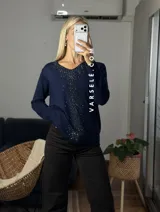 Sweater de punto color bordó con escote en V y detalle de strass aplicado en la parte frontal. Presenta mangas largas y corte holgado.