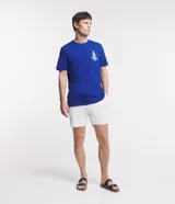 Bermuda de hombre, corte slim, color blanco con textura visible. Confeccionada principalmente en lino y algodón, con un pequeño porcentaje de elastano para mayor ajuste. Presenta cintura elástica y bolsillos laterales.