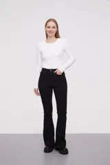 Pantalon jean de tiro alto con corte flare y terminación desflecada en el ruedo. Presenta un diseño clásico de cinco bolsillos con costuras en contraste.