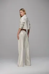 Pantalón de sarga color off-white con corte recto y tiro bajo. Presenta una aplicación integral de mini cristales brillantes, bolsillos laterales y bolsillos traseros geométricos.