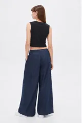 Top cropped negro de algodón con elastano, al cuerpo, con cuello redondo a la base y diseño sin mangas.