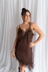 Vestido corto de satén negro, con tirantes finos, escote en V y detalles de encaje en el escote, el lateral y el dobladillo asimétrico.