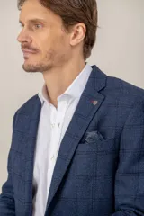 Saco de vestir con diseño de espiga en color marrón, confeccionado en mezcla de lana y seda. Presenta solapas clásicas, cierre frontal de dos botones y bolsillos laterales con solapa.