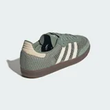 Championes Adidas Samba OG de diseño urbano, con exterior de malla y cuero en tono verde oliva. Presenta las icónicas tres tiras laterales en color crema, talón reforzado y suela de caucho color marrón.