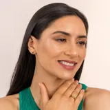 Anillo de plata 925 bañada en oro 18k con una piedra central de topacio azul rectangular y una esmeralda circular a cada lado.