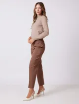 Pantalón de corte entallado y largo cropped, confeccionado en tejido con elasticidad técnica resistente a las arrugas. Presenta una pretina ancha y plana para un ajuste cómodo, bolsillos simulados en el frente y en la parte posterior, y pequeñas aberturas laterales en el ruedo.