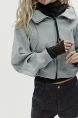 Cazadora de estilo deportivo con capucha ajustable, cierre frontal de doble cremallera y mangas abullonadas con puños elásticos. Presenta bolsillos delanteros y bajo elástico.