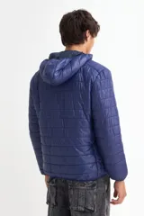 Campera puffer con capucha, cierre frontal y diseño acolchado de líneas horizontales.
