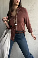 Camisa de tejido liviano y calce relajado, color marrón chocolate, con cuello mao, mangas largas y detalle de puntilla y bordado en contraste a lo largo de la botonadura frontal.