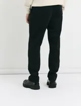 Pantalón jogging de corte recto, confeccionado en tejido circular con cintura elástica y cordón ajustable al tono. Presenta bolsillos laterales tipo parche.