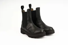 Bota tipo Chelsea de cuero negro con caña media, paneles laterales elásticos y suela track dentada.