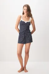 Pijama corto de color azul marino con pequeño estampado floral blanco, compuesto por una musculosa con detalles de encaje en el escote y un short con cordón ajustable en la cintura.