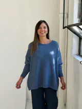 Sweater de punto color azul, con cuello redondo, corte holgado y mangas largas con puños ajustados.