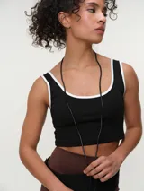 Top deportivo negro con ribetes blancos en el cuello y las sisas, de corte corto a la cintura.