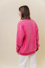 Sweater de tejido suave con lavado efecto vintage, color rosa fucsia, de calce oversize y cuello redondo.