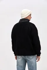 Buzo de sherpa con textura capitoneada, diseño de medio cierre y cuello alto en color beige contrastante. Presenta un calce holgado, mangas largas con puños elásticos y bolsillos laterales.