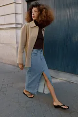 Chaqueta de corte recto y estilo camisero en color beige, con cuello solapa, manga larga y cierre frontal con botones. Presenta dos bolsillos delanteros de plastrón.