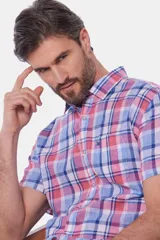 Camisa de lino de manga corta con diseño a cuadros en tonos azul, verde y blanco, con cuello camisero y cierre frontal de botones.