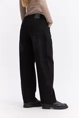 Jean de corte balloon con tiro alto y silueta amplia que se estrecha ligeramente hacia el tobillo. Presenta un diseño de cinco bolsillos, cierre frontal con botón y bragueta, y costuras reforzadas.