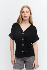 Remera negra con escote en V y cierre frontal con botones.