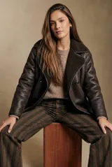 Campera tipo gamulan de corte oversize, color marrón oscuro con interior y solapas de corderito al tono. Presenta cierre frontal y mangas largas.