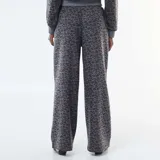 Pantalón de corte ancho con estampado de leopardo en tonos grises, confeccionado en tejido suave, con cintura elástica y cordón ajustable.