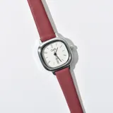 Reloj de pulsera con caja plateada de forma cuadrada y correa de cuero sintético color borgoña.
