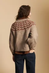 Sweater de tejido jacquard con diseño geométrico en color marrón sobre base beige, de cuello redondo y manga larga con puños ajustados.