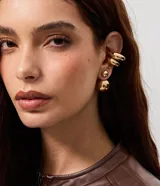 Kit de aros dorados con acabado brillante y efecto espejado, compuesto por pendientes tipo ear jacket con esferas de distintos tamaños y piercings de presión voluminosos para la oreja.