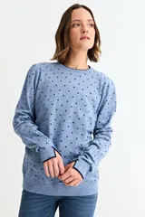 Sweater de tejido de punto fino en color azul melange, con estampado de pequeños corazones negros. Presenta cuello redondo, mangas largas y puños con detalle de borde en contraste.