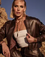 Collar largo dorado con cadena de eslabones entrelazados y colgante en forma de punta de flecha.