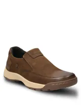 Zapatos tipo slip-on Hush Puppies modelo Consin, confeccionados en cuero color marrón, con suela de goma y detalles de costuras visibles.