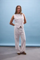 Pantalón blanco de corte ancho y tiro medio/bajo con cordón ajustable en la cintura.