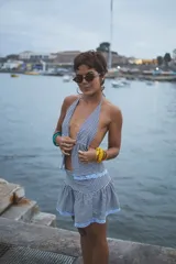 Top corto con estampado de cuadros vichy en blanco y negro, escote halter y lazo ajustable en el frente. El ruedo está decorado con encaje celeste.