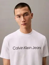 Remera blanca de algodón con cuello redondo y logo "Calvin Klein Jeans" estampado en el pecho.