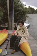 Abrigo de mezcla de lana color beige claro, de corte oversize y largo medio. Presenta un cuello solapa envolvente con detalle de pañuelo integrado y manga larga. Cierre frontal cruzado con botones ocultos.