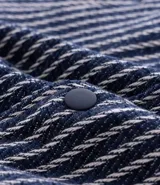 Campera masculina de corte recto con textura jacquard a rayas verticales en tonos azul marino y blanco. Presenta cuello inglés, cierre frontal con botones y manga larga.