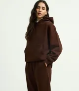 Pantalón jogger de corte holgado, confeccionado en tejido fleece color beige. Presenta cintura elástica, bolsillos laterales y puños ajustados en el bajo.