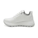 Championes deportivos Via Marte modelo Adeline, color blanco con plataforma y suela dentada. Presentan pasadores de cordones blancos, puntera perforada y logo metálico lateral en forma de letra "V".