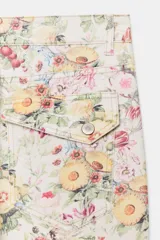 Jeans rectos de tiro medio con estampado floral multicolor sobre base blanca, trabillas para cinto, bolsillos delanteros y cierre frontal con cremallera y botón metálico.