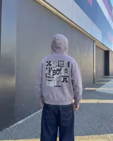 Canguro con capucha de calce regular en color gris con efecto stone wash. Presenta un estampado gráfico en la espalda con estilo de cómic que incluye la palabra 'BO!' en un globo de texto y diversos dibujos.