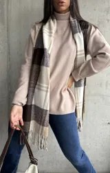 Polera beige de cuello alto y manga larga.